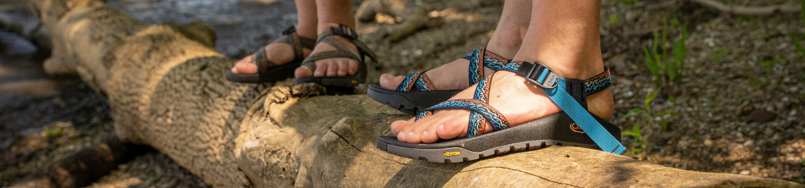 View of people sandals on fallen tree branch