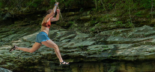 Photo of woman jumping into creek